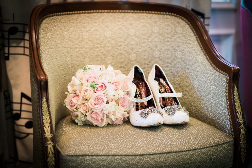 Sofá estampado con ramo de novia y zapatos blancos